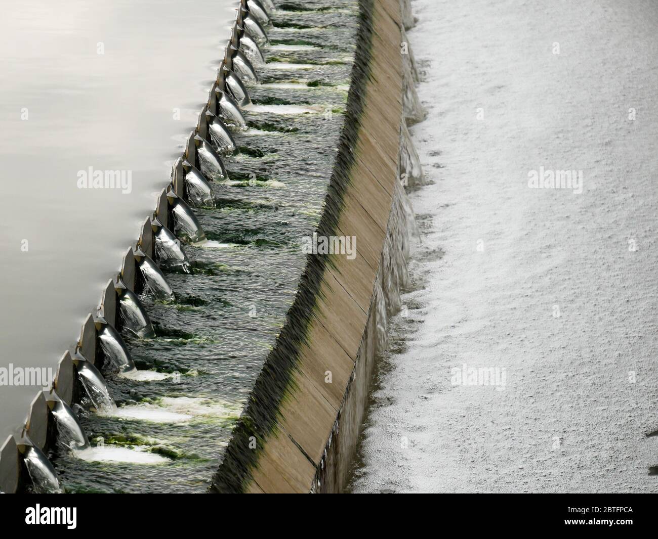 Dettaglio del flusso di acque reflue su un serbatoio di sedimentazione secondario durante il processo di trattamento vista laterale Foto Stock