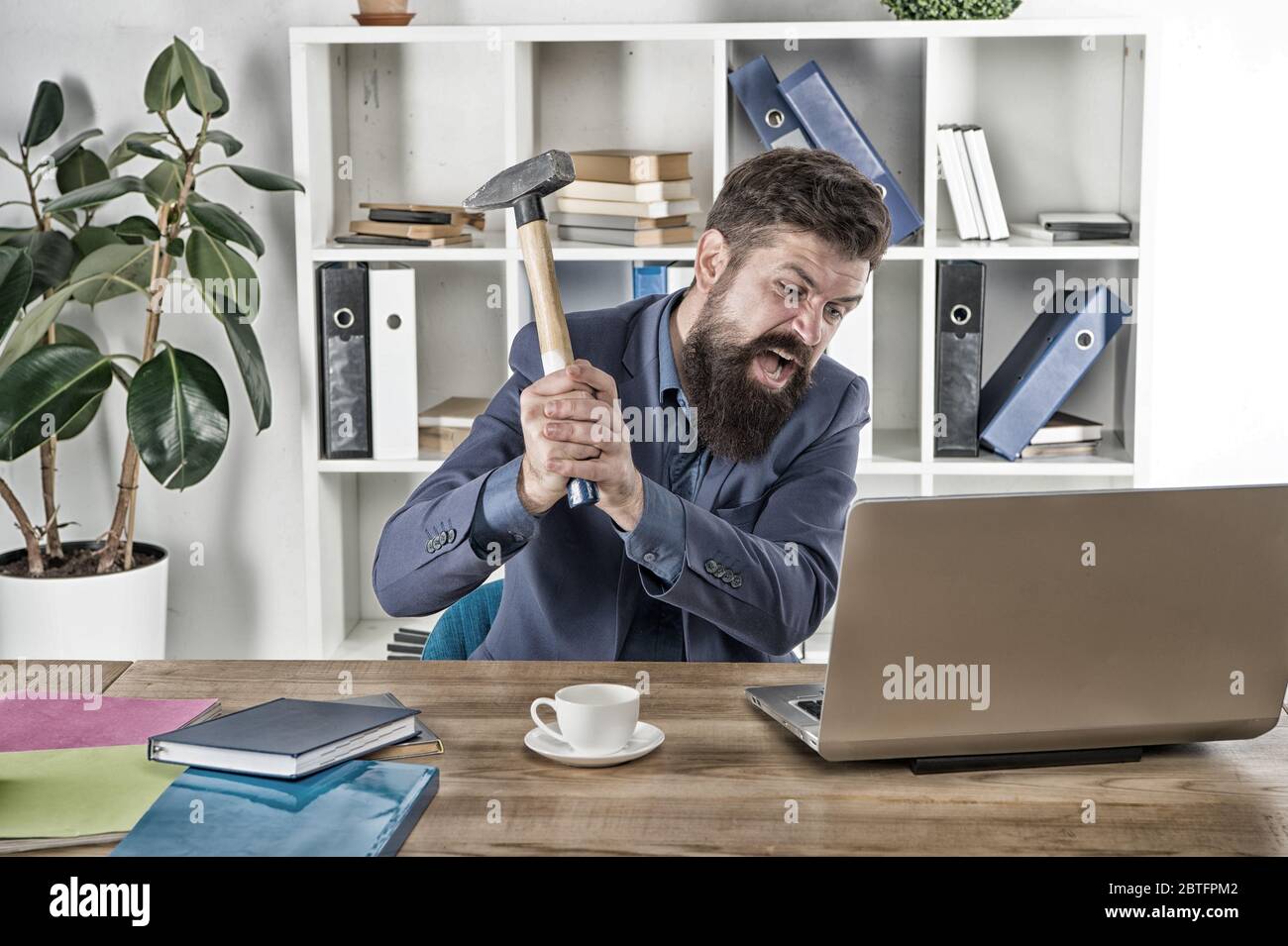 Emozioni umane. Virus del ritardo del computer. Uomo d'affari arrabbiato o manager con il martello. Uomo d'affari aggressivo in ufficio. Motivi per il ritardo del computer. Odiate la routine dell'ufficio. Risolvi alcuni problemi aziendali. Foto Stock
