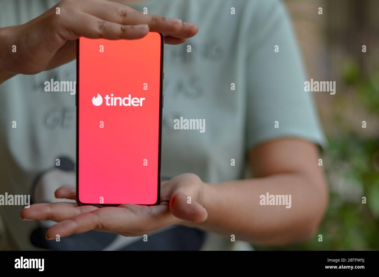 Nuova Delhi, India, 2020. Ragazza che tiene il cellulare con il logo Tinder sullo schermo dello smartphone in mani femminili. Tinder è un'applicazione mobile di ricerca e datazione sociale Foto Stock
