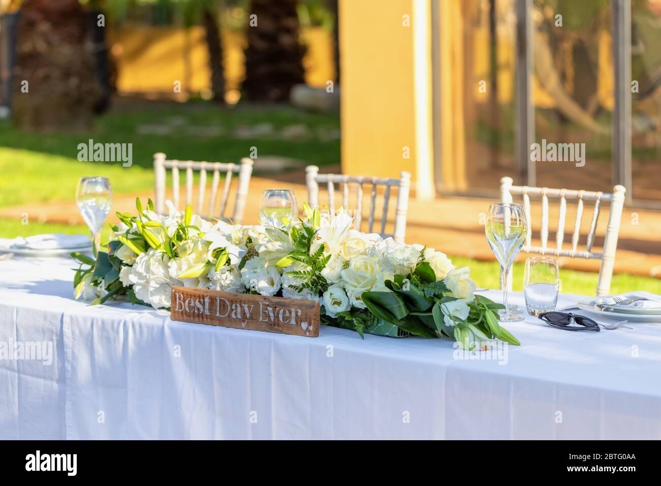 Un tavolo da nozze decorato in origine con fiori sul soleggiato prato dell'hotel. Foto Stock