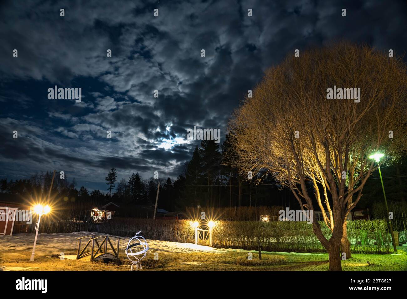 Giardino svedese di notte, luna piena accanto alle nuvole, primavera, neve d'inverno qui Foto Stock