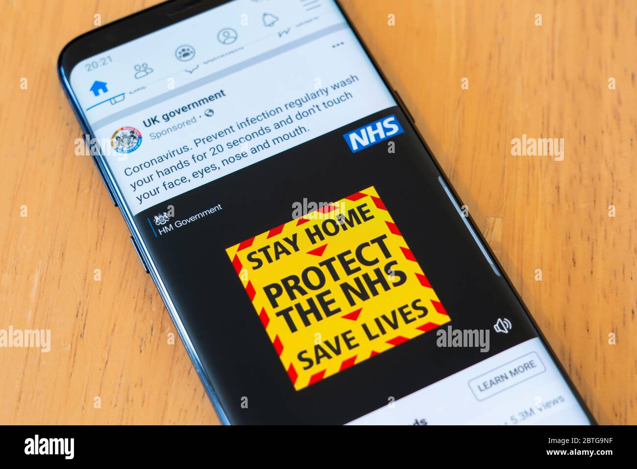 Un annuncio del governo britannico su uno smartphone che avverte il pubblico britannico di rimanere a casa, proteggere l'NHS e salvare vite umane. Covid 19 Coronavirus Foto Stock