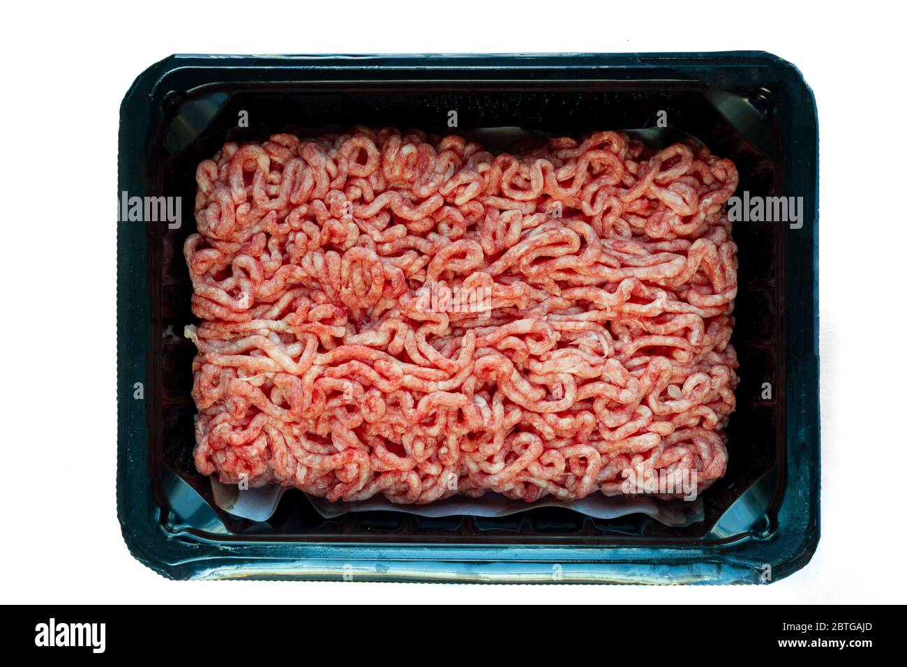 Carne macinata grezza su un piatto nero di plastica, fondo bianco isolato Foto Stock