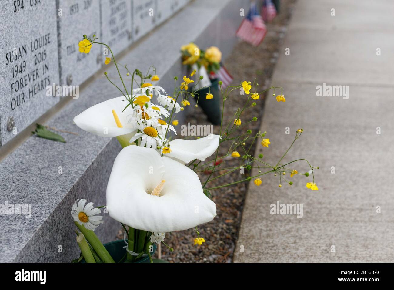 Portland, Stati Uniti. 25 Maggio 2020. Il cimitero nazionale di Willamette ha annullato per la prima volta le cerimonie del Memorial Day in oltre cinquant'anni a causa della pandemia del covid-19, ma nonostante le piogge, molte famiglie sono venute a collocare fiori e bandiere sulle tombe dei parenti a Portland, Oregon, il 25 maggio 2020. (Foto di John Rudoff/Sipa USA) Credit: Sipa USA/Alamy Live News Foto Stock