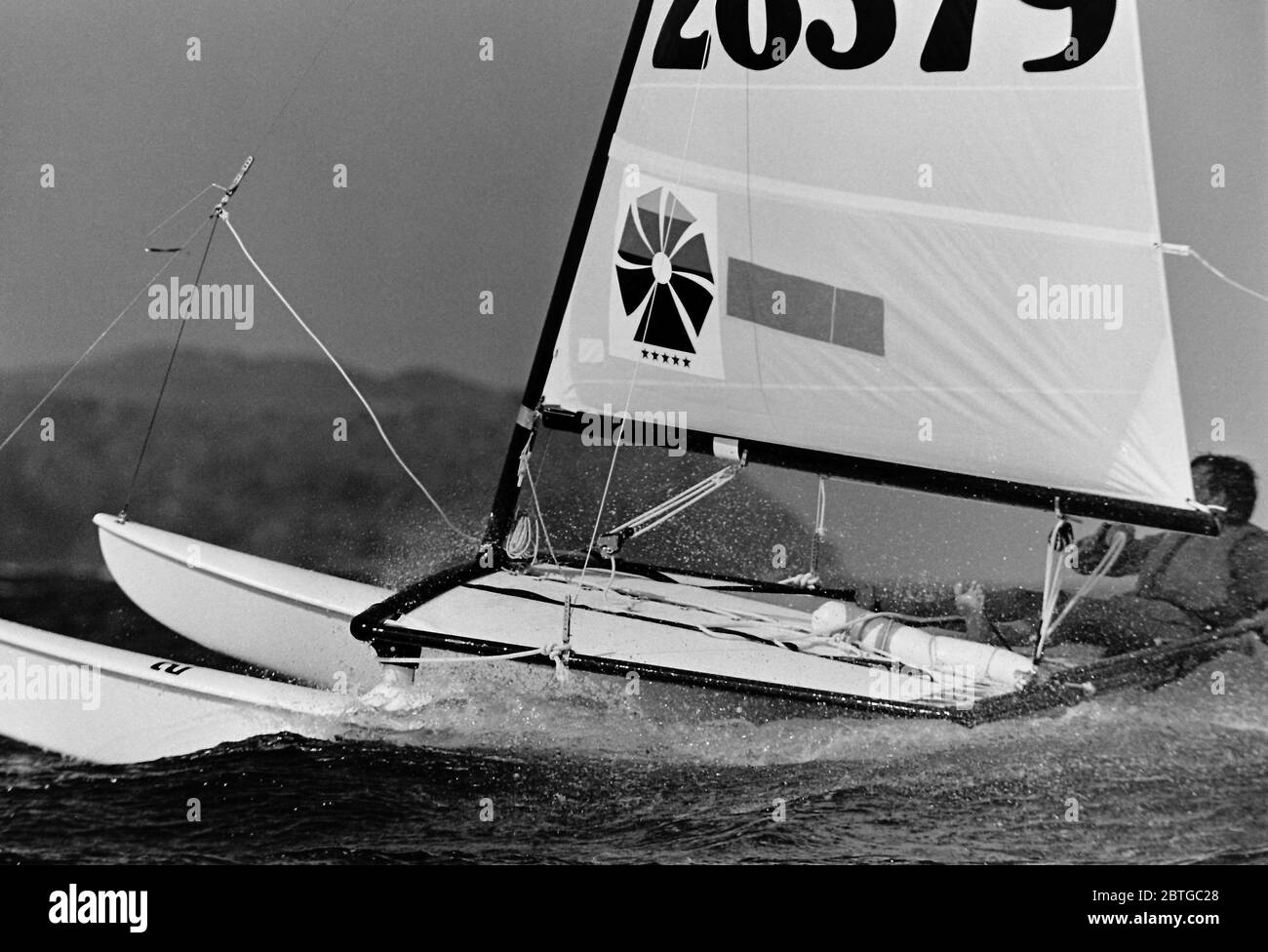 AJAXNETPHOTO. 1977. BAIA DI LAS SALINAS, LANZAROTE, SPAGNA. UN CONCORRENTE CHE CORRE IN UNA BREZZA FRANGENTE E IN ACQUE AGITATE NEI CAMPIONATI DEL MONDO HOBIE CAT 14. PHOTO:JONATHAN EASTLAND/AJAX REF:7726091 30 Foto Stock