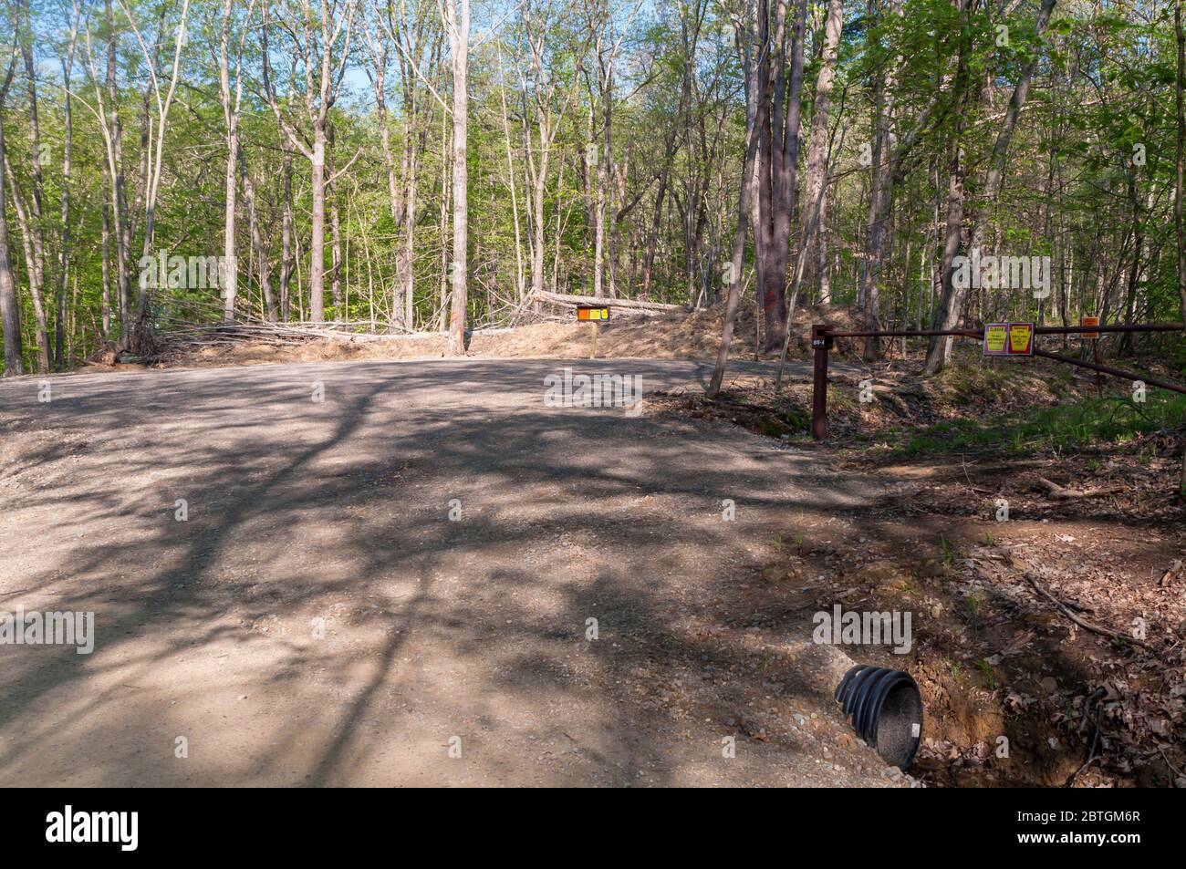 Un parcheggio sporco vicino a un cancello che conduce a terre di gioco di stato in una giornata di primavera soleggiata nella contea di Warren, Pennsylvania, Stati Uniti Foto Stock