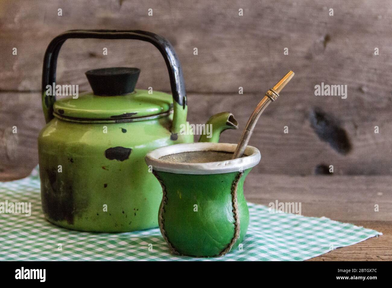 Matraccio e bollitore, tradizionale argentino yerba mate infusione, su rustico legno sfondo Foto Stock