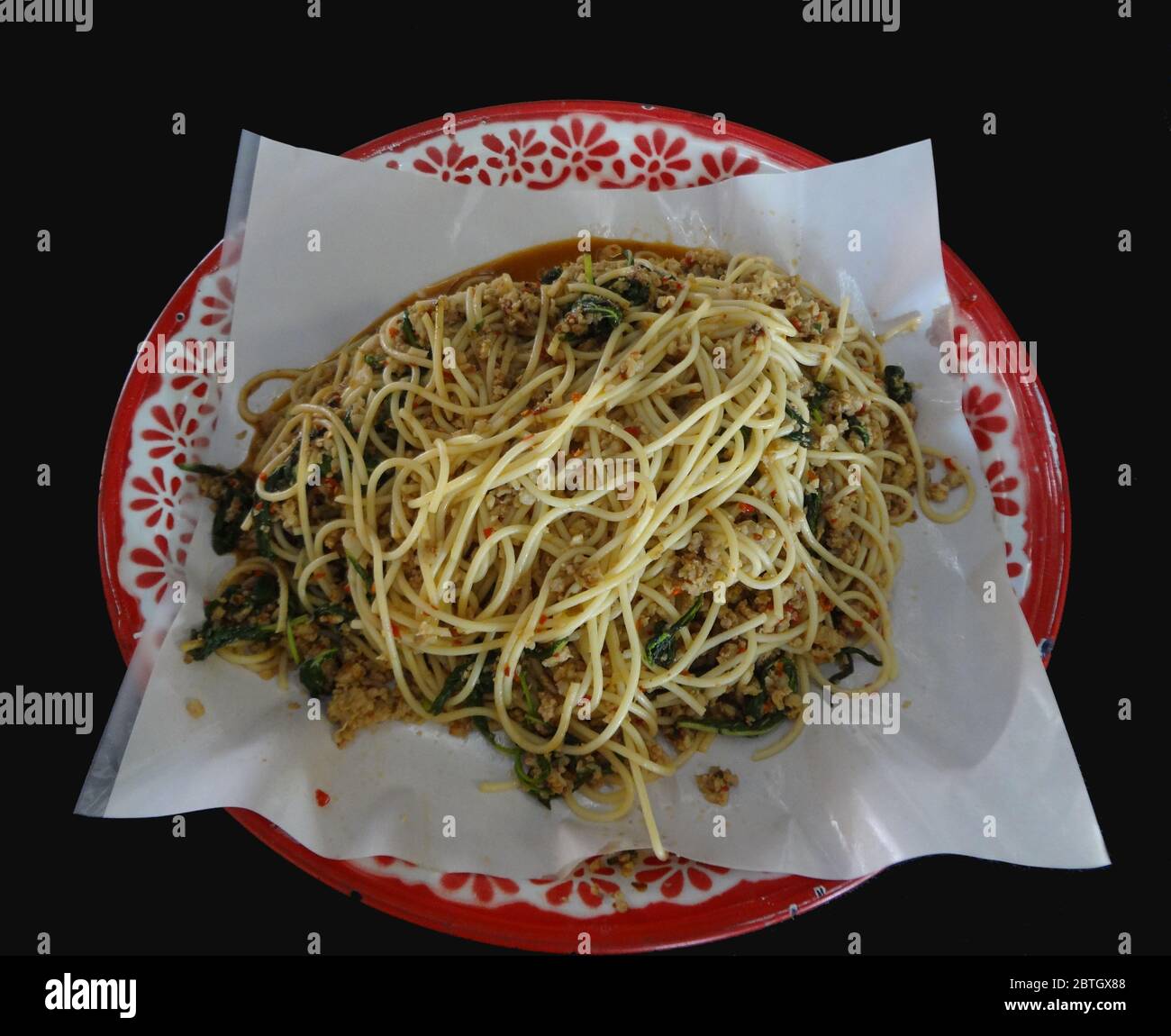 Spaghetti fritti con salsa piccante o spaghetti fritti con pollo tritato e basilico santo su vassoio, cibo in stile tailandese Foto Stock