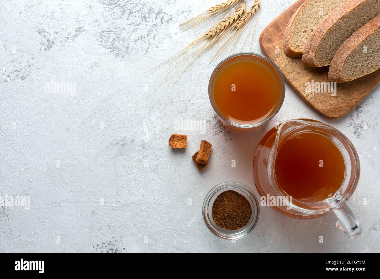 Calza in un bicchiere e una caraffa su uno sfondo chiaro. Bevanda tradizionale con pane al malto di segale. Vista dall'alto, posiziona per il testo. Foto Stock