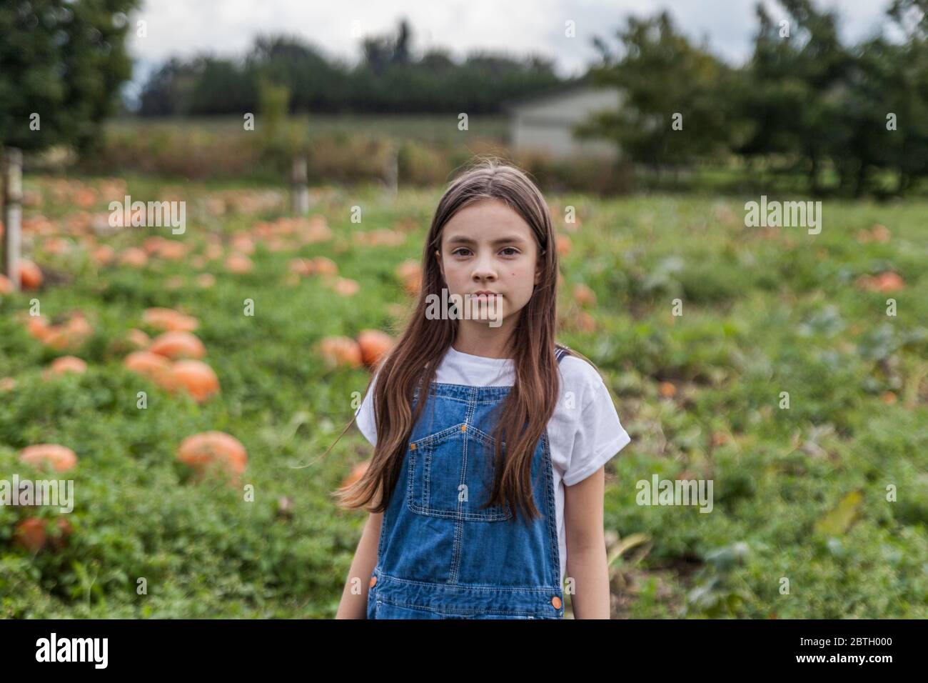Cute ritratto della bambina in un tegolo di zucca con sfondo sfocato. Foto Stock