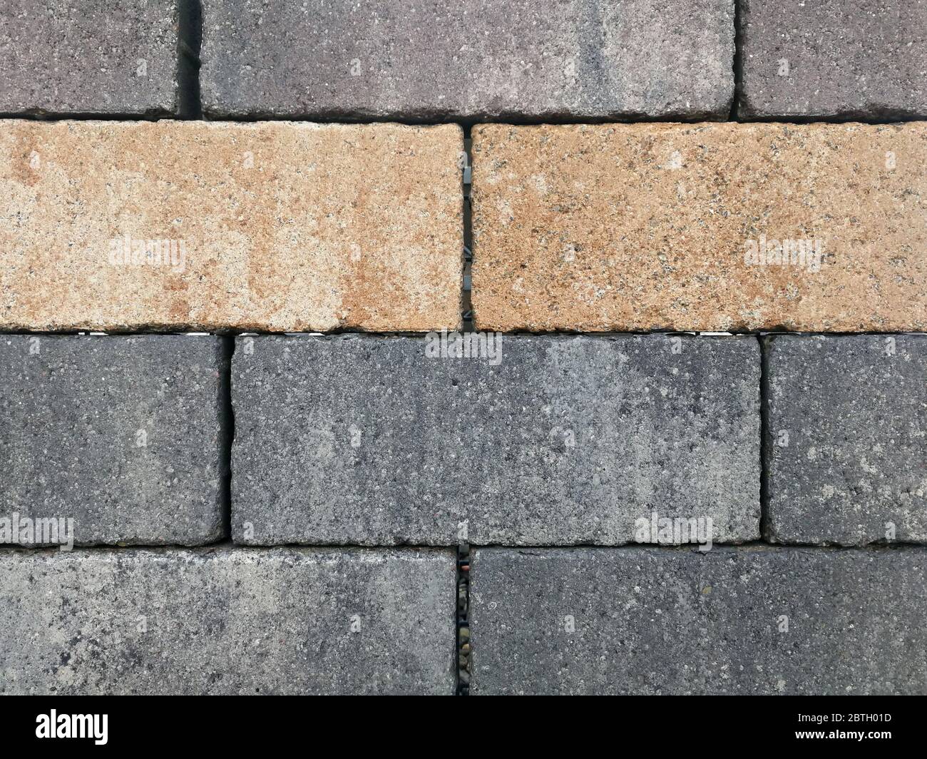 Mattoni, pietre di pavimentazione, impilati come un muro, come sfondo. Foto Stock