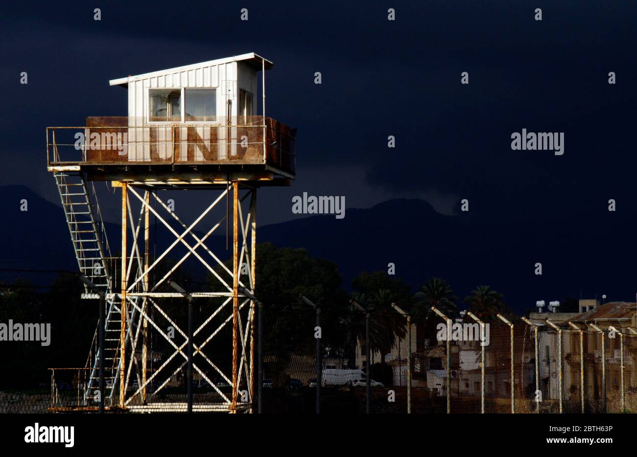 Nicosia, Cipro - 12 febbraio 2020: Una torre di guardia delle Nazioni Unite intemperie illuminata dal sole con nubi oscure tuose sullo sfondo. Foto Stock