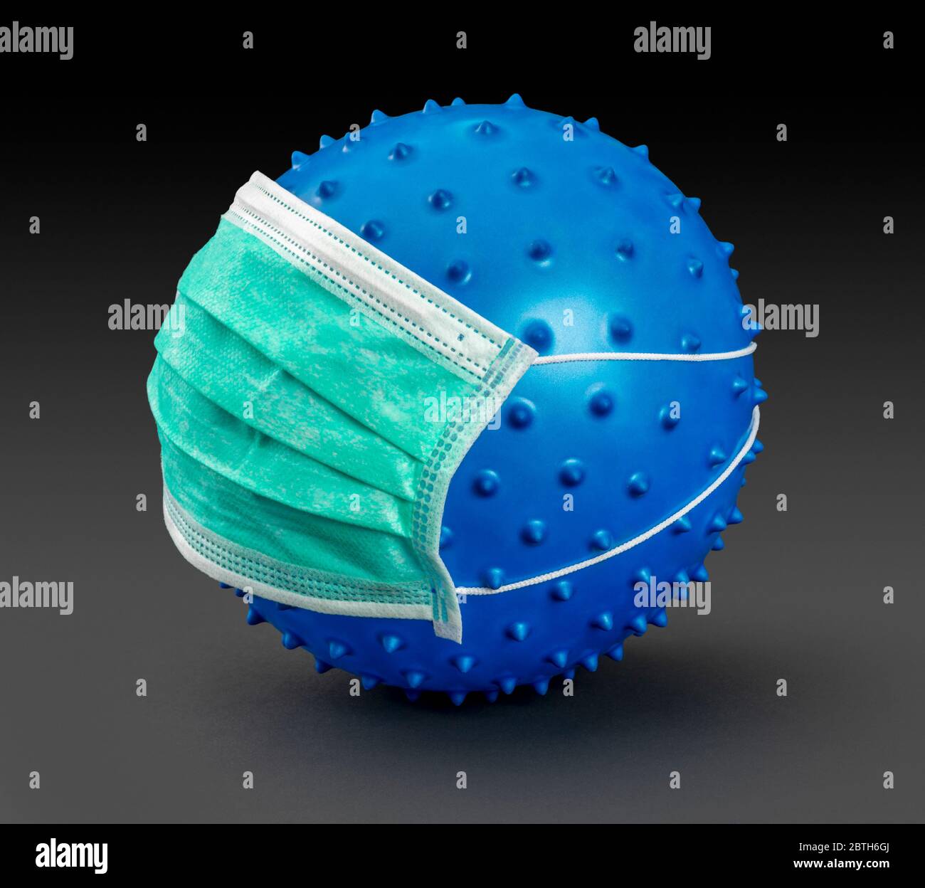 immagine di un virus blu simbolico che indossa una maschera facciale nella parte posteriore scura Foto Stock