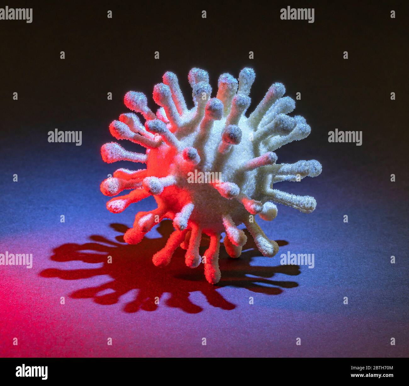 immagine di un colorato virus simbolico illuminato in scuro retro Foto Stock