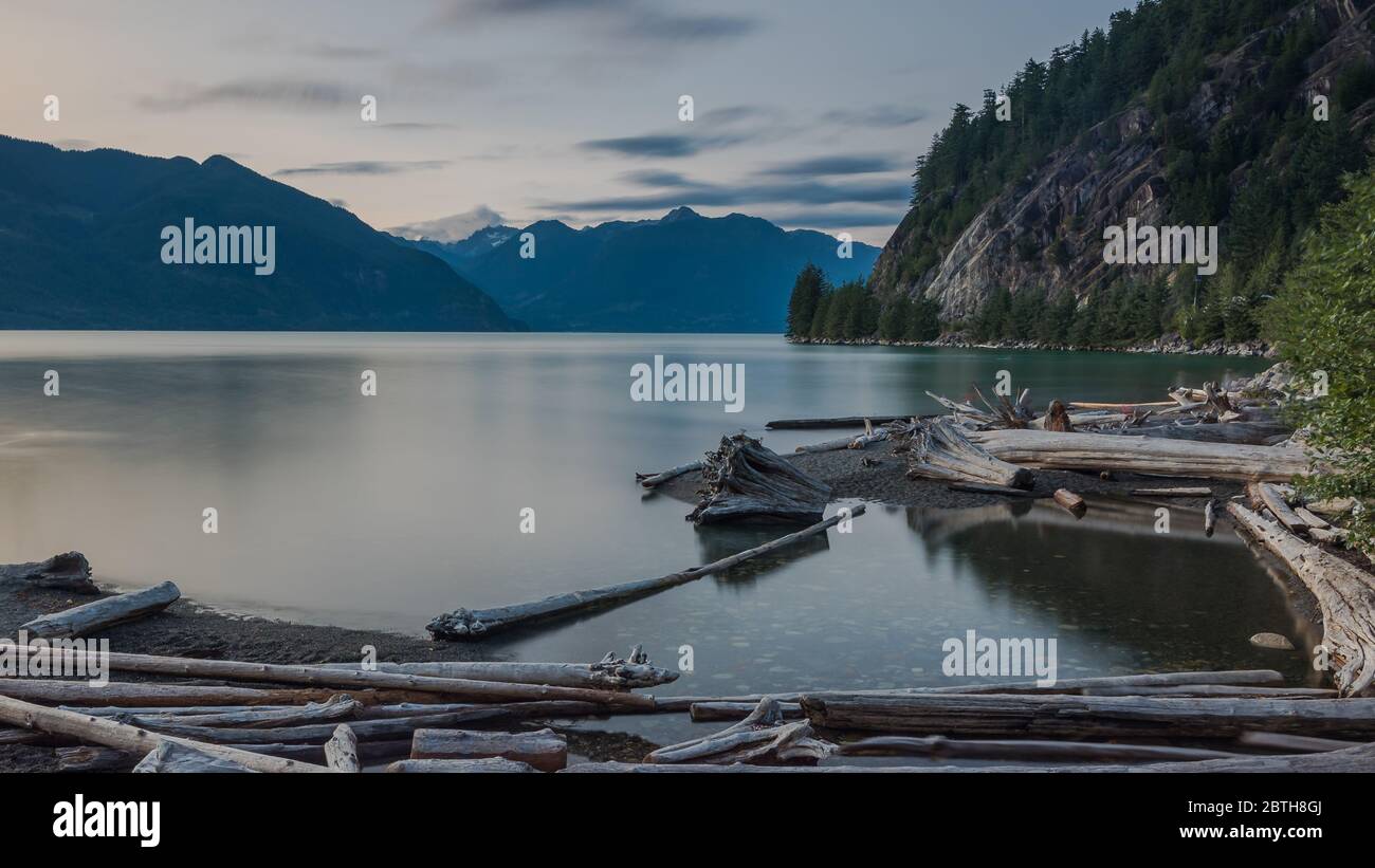 Porteau Cove alla fine di una giornata estiva. L'acqua è calma e molti tronchi possono essere visti in primo piano. La sede è a BC, Canada Foto Stock