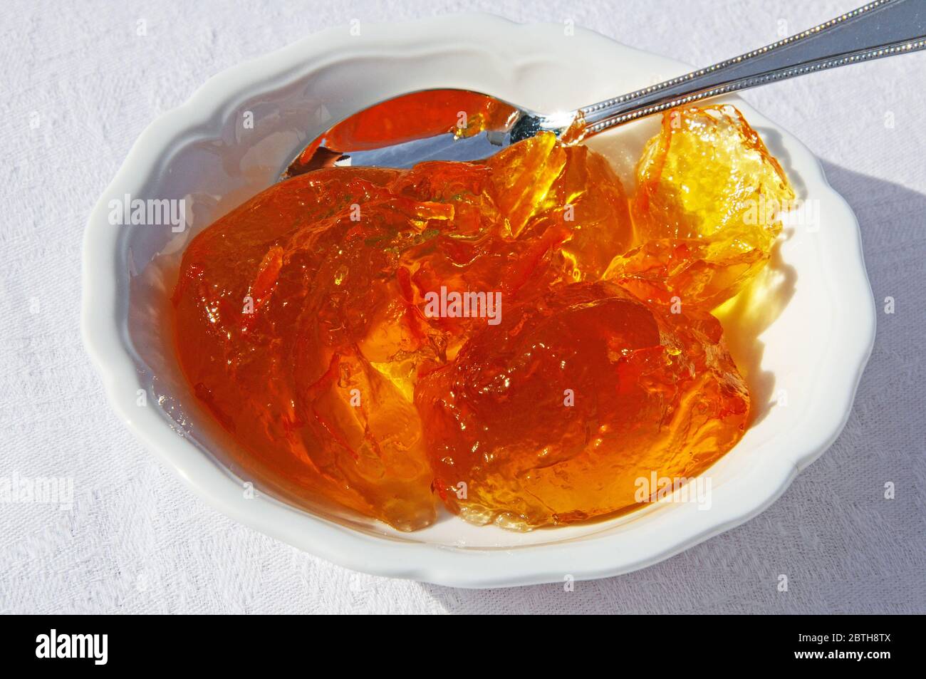 Marmellata di arance in un bianco piatto di ceramica con un cucchiaio d'argento. Foto Stock