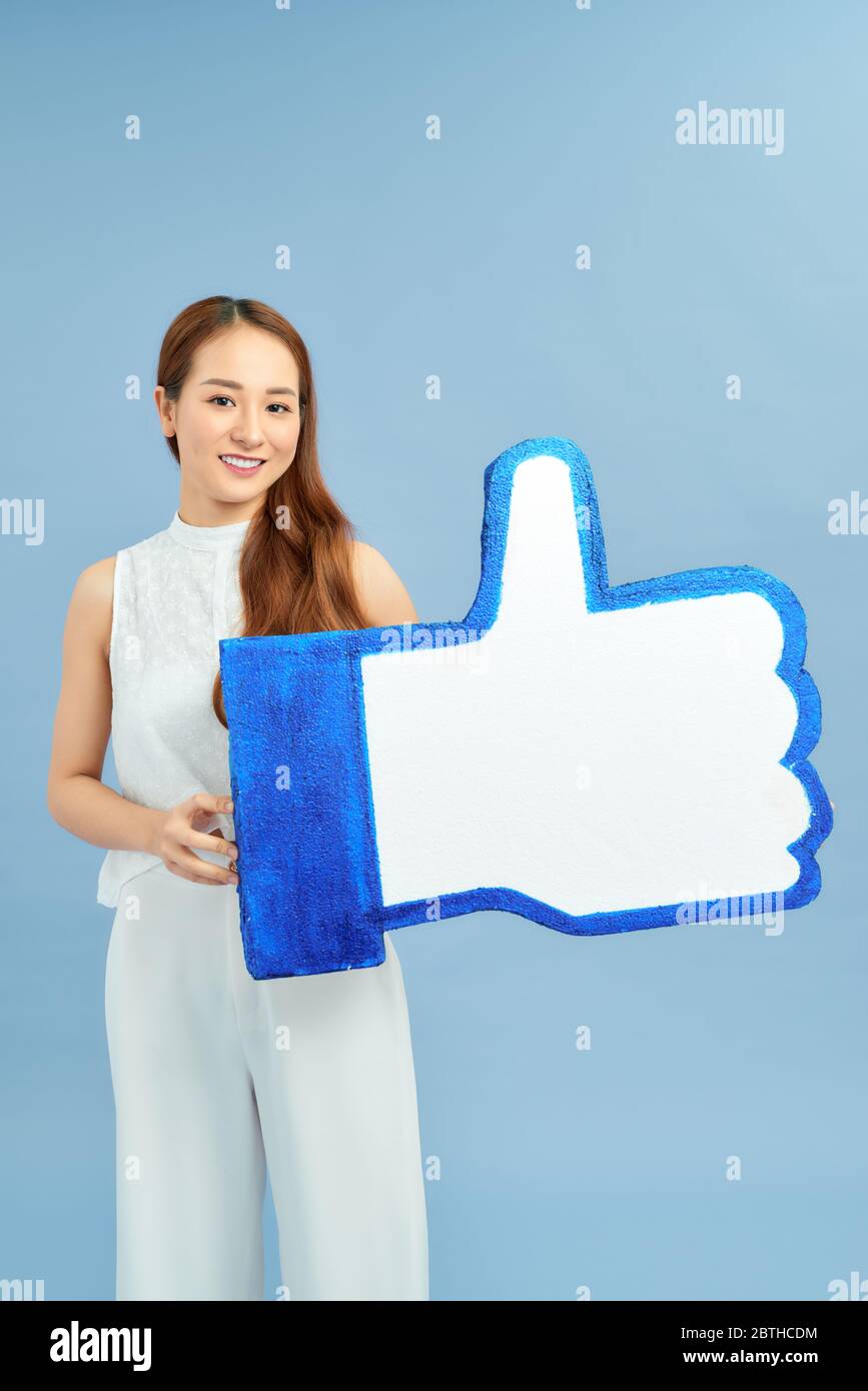 bella ragazza sorridente che tiene i social media come pulsante Foto Stock