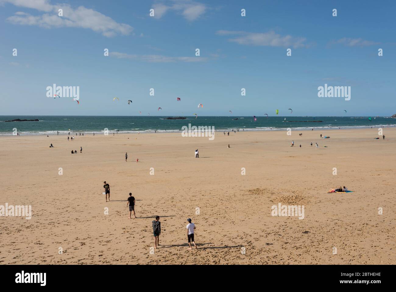 Persone che volano aquiloni sulla spiaggia di sabbia, St Malo, Bretagna, Francia Foto Stock