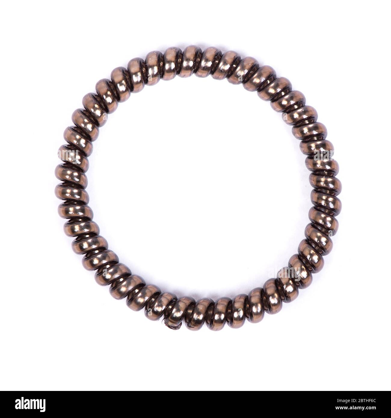 Una spirale elastica marrone per capelli isolati su sfondo bianco. Articolo in plastica flessibile per capelli femminili o braccialetti. Foto Stock