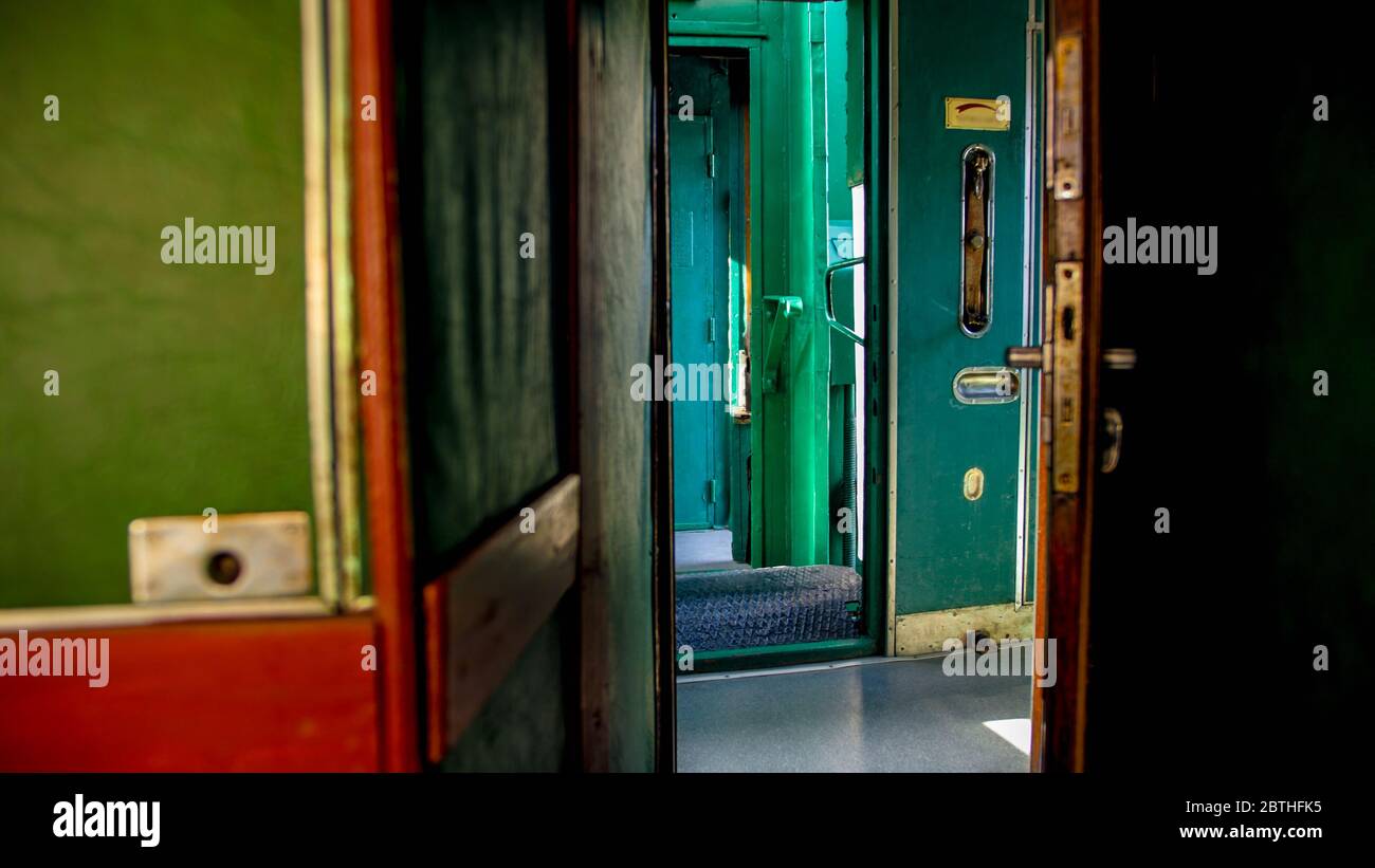 Interno di una vecchia macchina del treno a vapore con lungo corridoio di legno Foto Stock