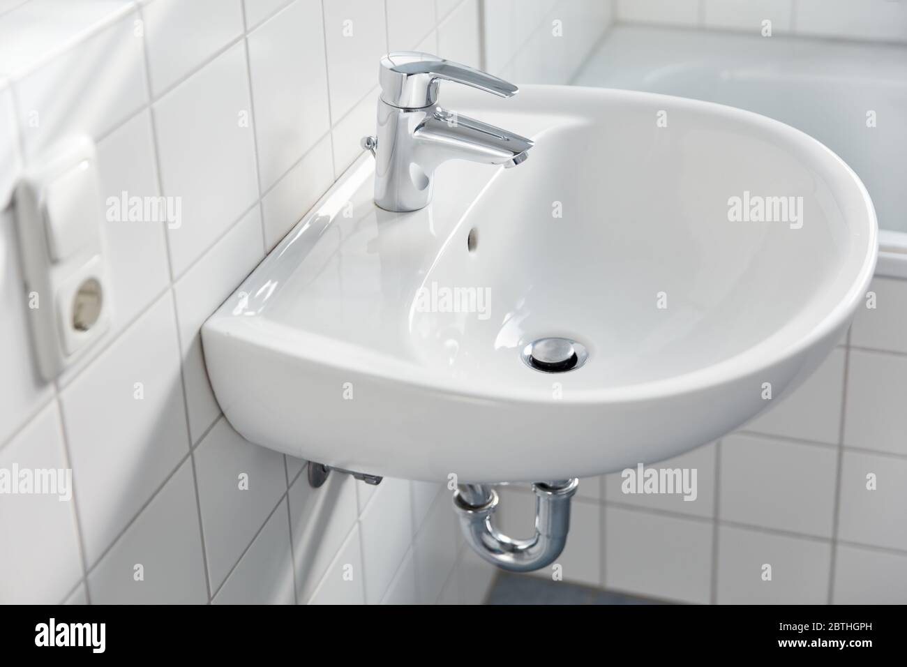 Lavandino con rubinetto e piastrelle bianche nel bagno di casa Foto Stock