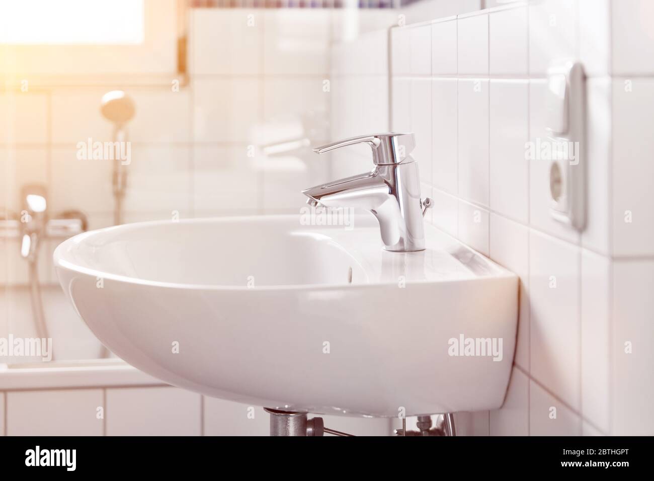 Lavandino bianco pulito in bagno con piastrelle a casa Foto Stock