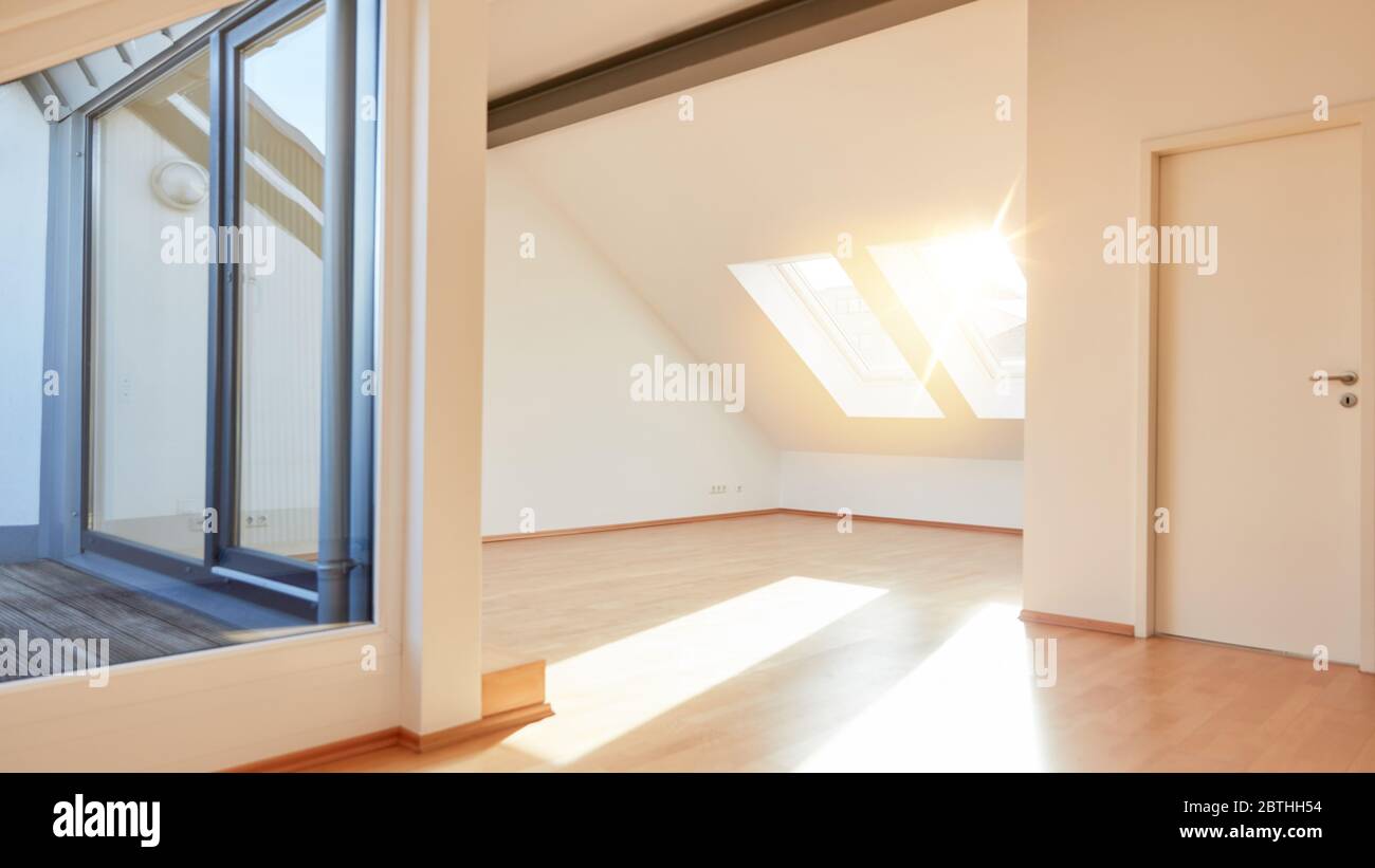Luminoso appartamento soleggiato all'ultimo piano con spazio vuoto e terrazza sul tetto a casa durante il giorno Foto Stock