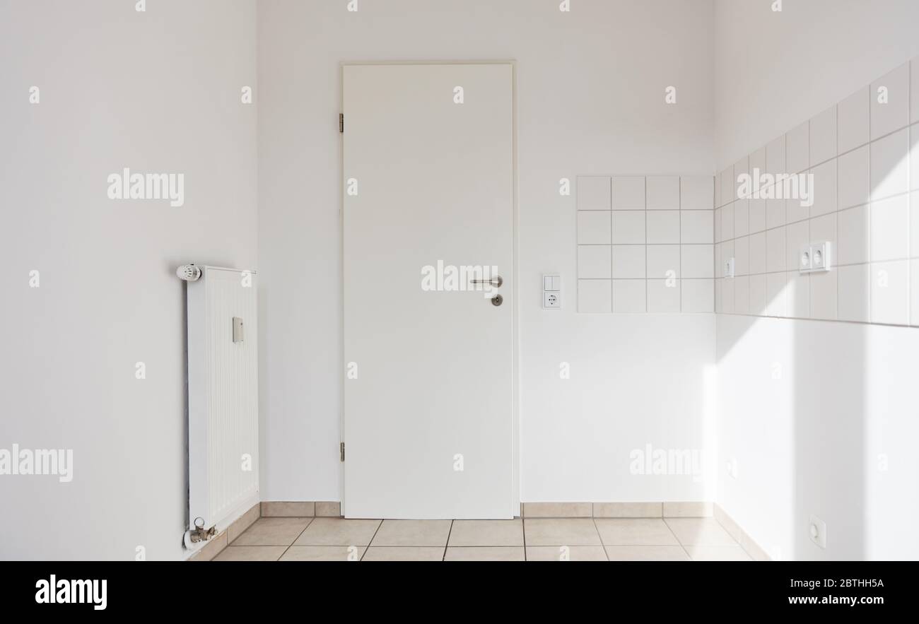 Camera vuota con piastrelle sul muro e porta come una cucina o bagno a casa Foto Stock