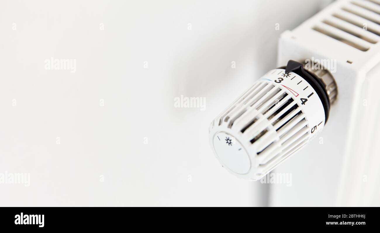 Regolatore di temperatura con termostato sul radiatore da un riscaldatore bianco Foto Stock