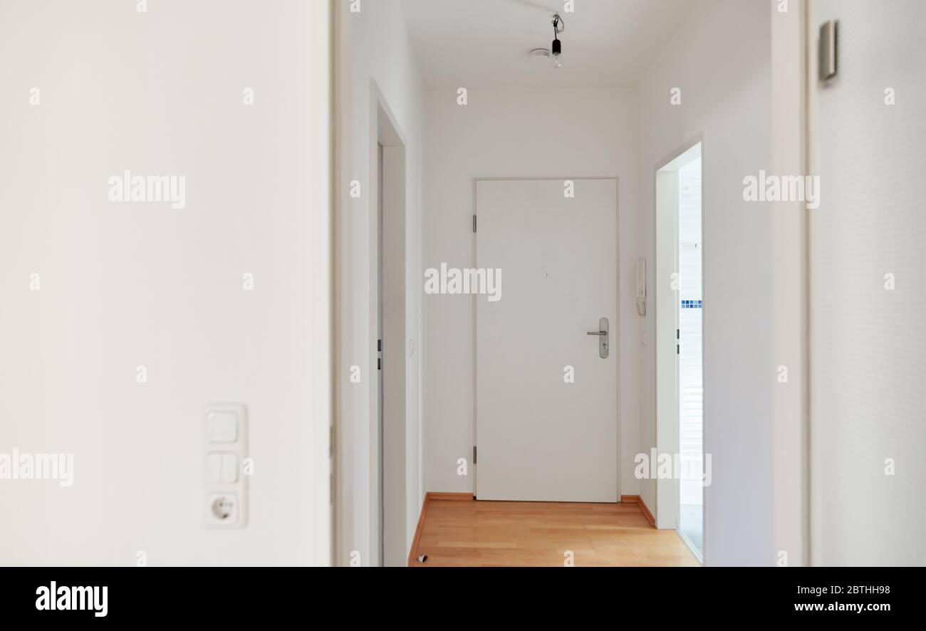Corridoio con parquet di legno duro e porta dell'appartamento in appartamento dopo la ristrutturazione Foto Stock