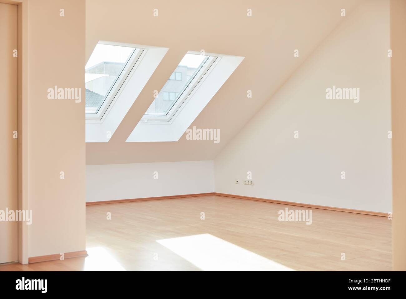 Luminosa camera vuota in appartamento mansardato con parquet a casa nel giorno Foto Stock