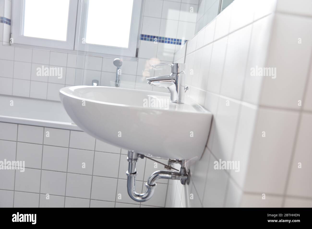 Piastrelle bianche nel bagno con lavello e vasca a casa Foto Stock