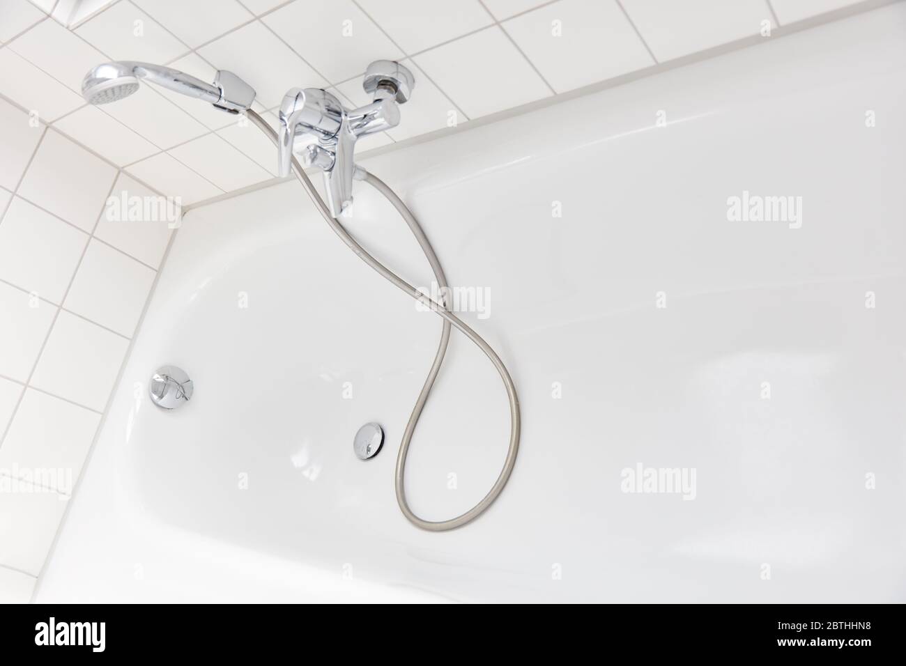 Doccia con soffione accanto alla vasca in un bagno luminoso a casa Foto Stock
