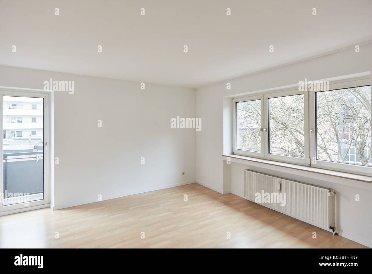 Camera vuota con balcone e finestra come luminoso soggiorno in appartamento dopo il rinnovo Foto Stock