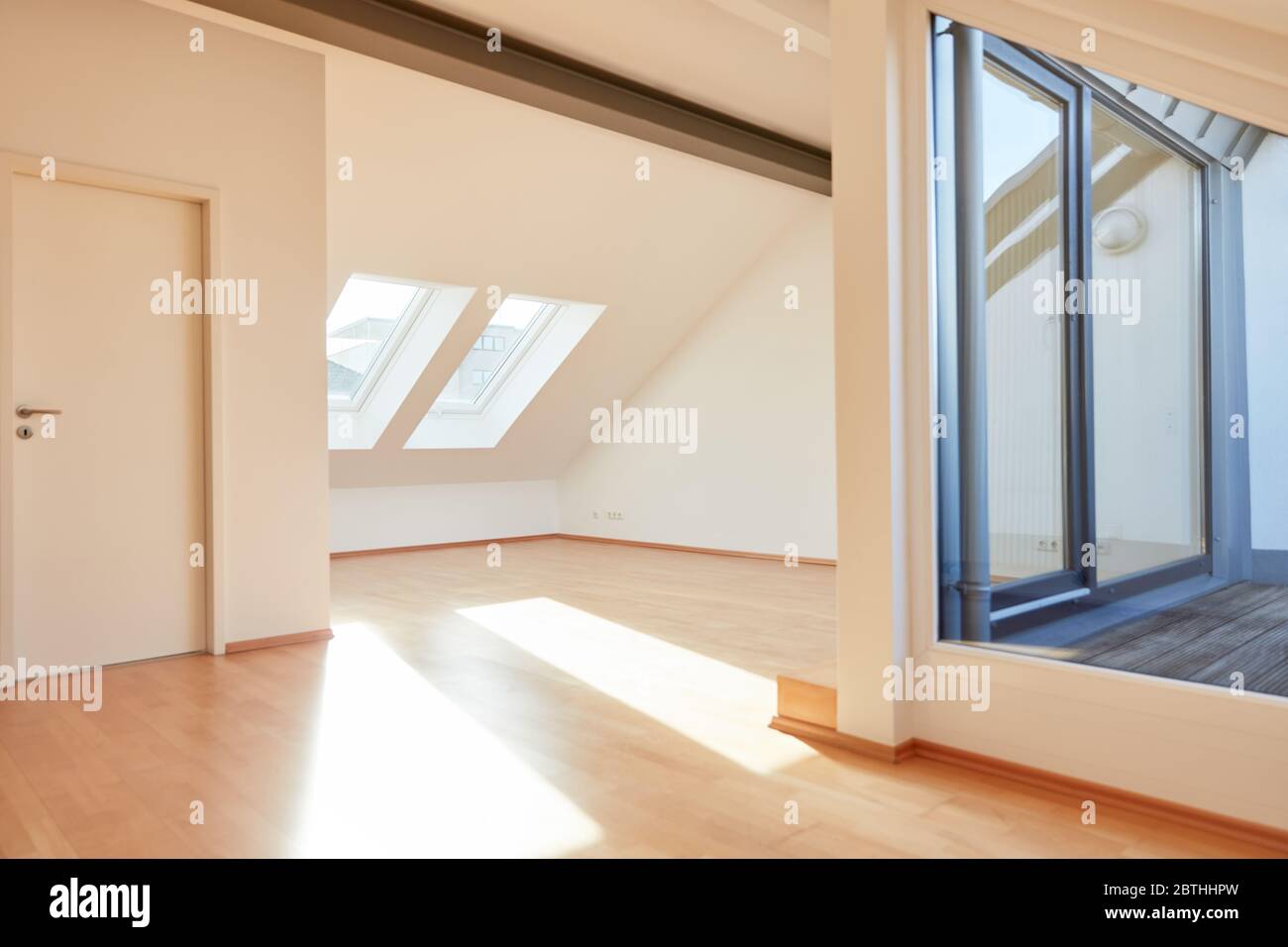 Luminoso appartamento mansardato soleggiato con spazio vuoto nel tetto spiovente e balcone Foto Stock