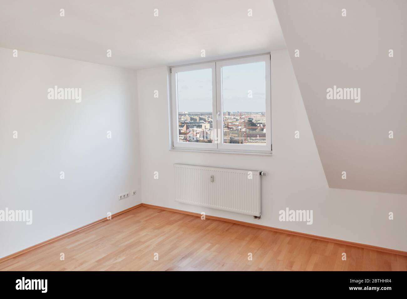 Camera vuota e luminosa in un attico con parquet in legno a Berlino Foto Stock