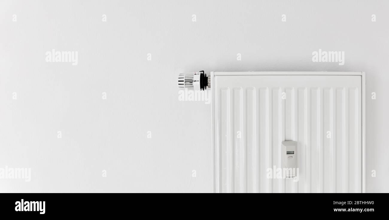 Riscaldamento con radiatore a pannello e allocatore di costi di calore e termostato a parete Foto Stock