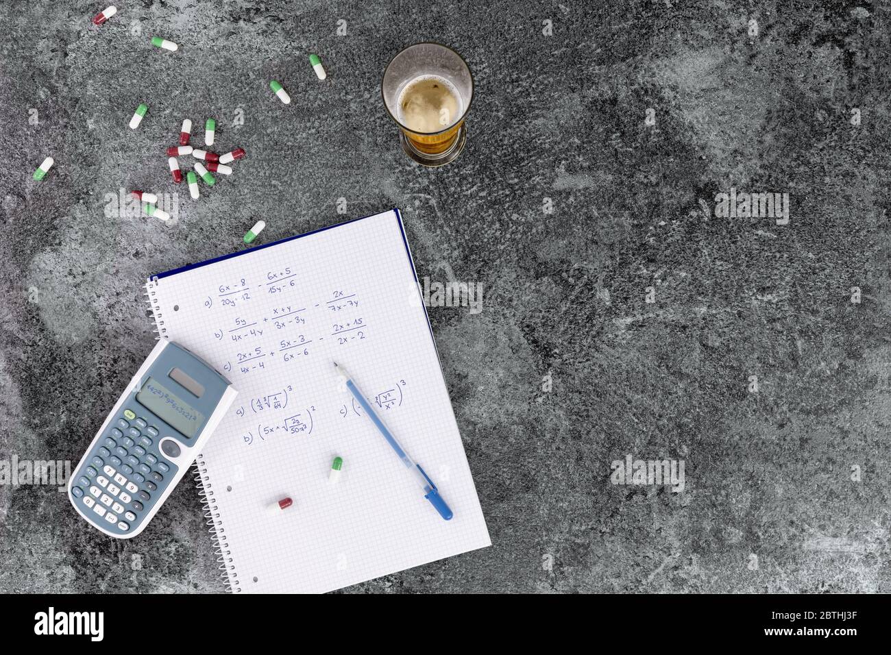 l'eccessivo consumo di alcol, droghe e medicinali danneggia la salute e ostacola l'apprendimento, note scritte a mano. calcolatrice bicchiere da birra e pillole su Foto Stock