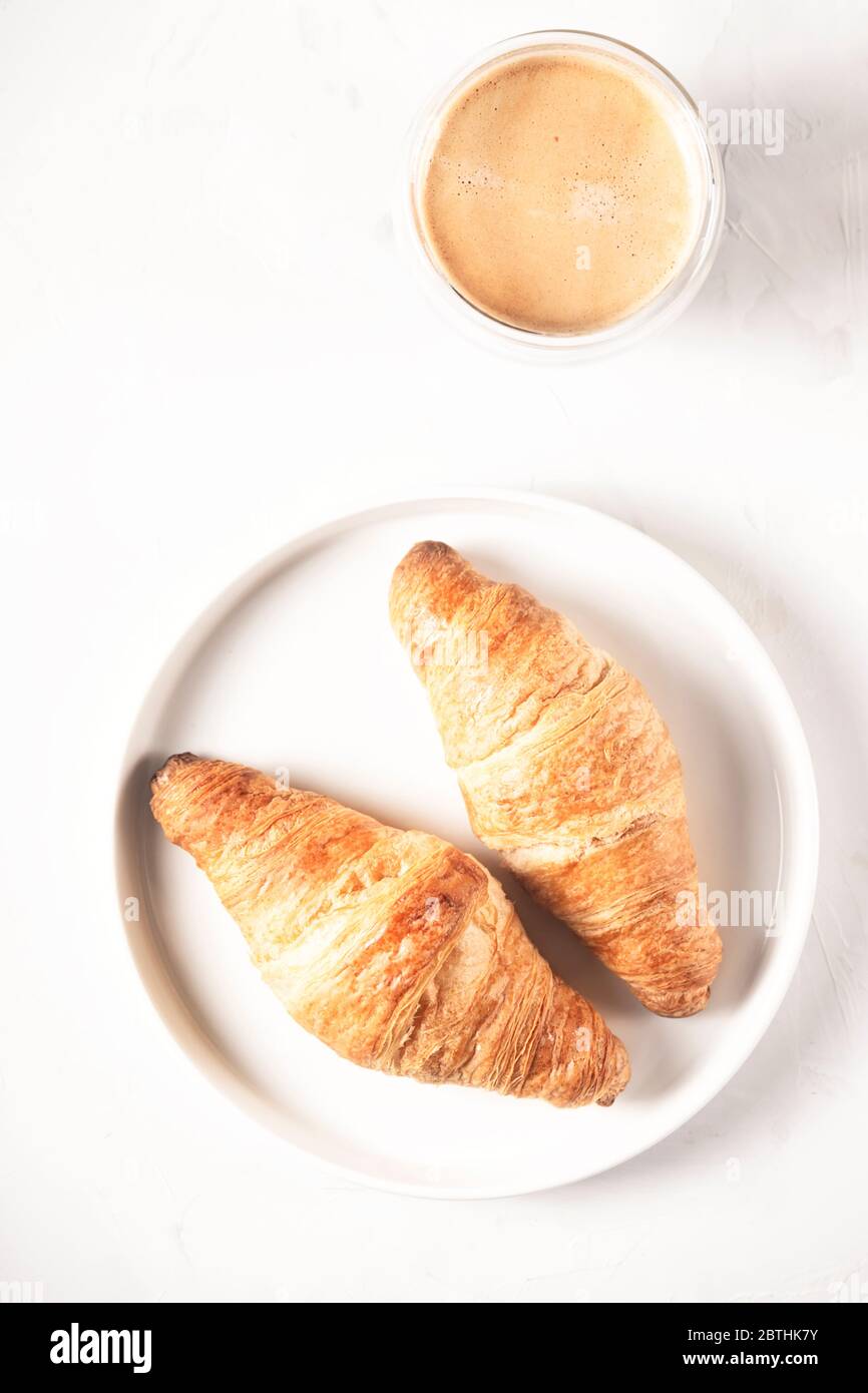 Croissant e caffè in stile minimalistico. Foto Stock
