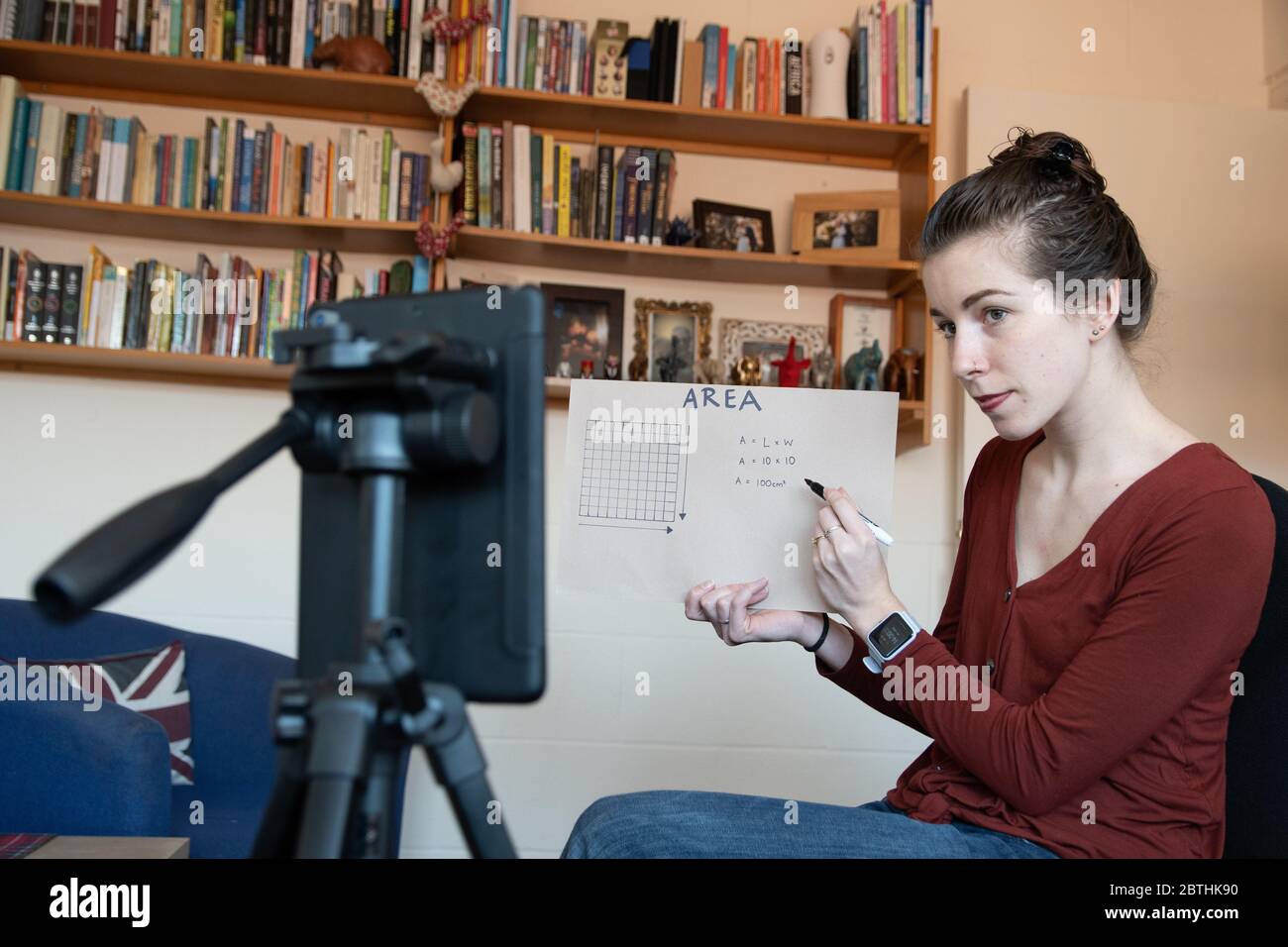 Gli insegnanti della scuola sono costretti ad insegnare le loro lezioni da casa online virtualmente utilizzando i loro telefoni per video se stessi sotto covid-19 coronavirus UK USA Foto Stock
