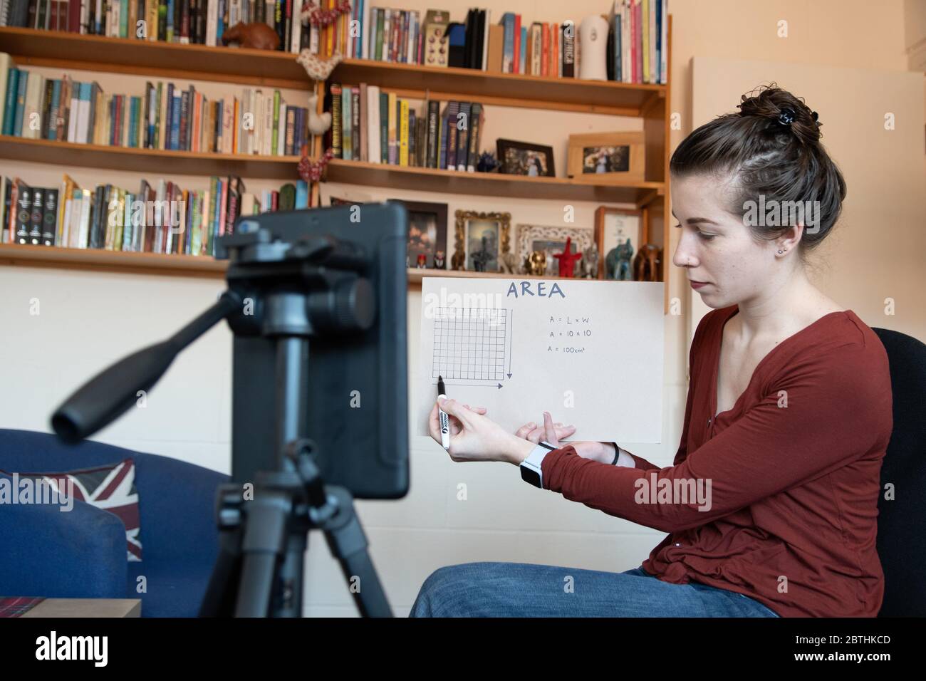 Gli insegnanti della scuola sono costretti ad insegnare le loro lezioni da casa online virtualmente utilizzando i loro telefoni per video se stessi sotto covid-19 coronavirus UK USA Foto Stock