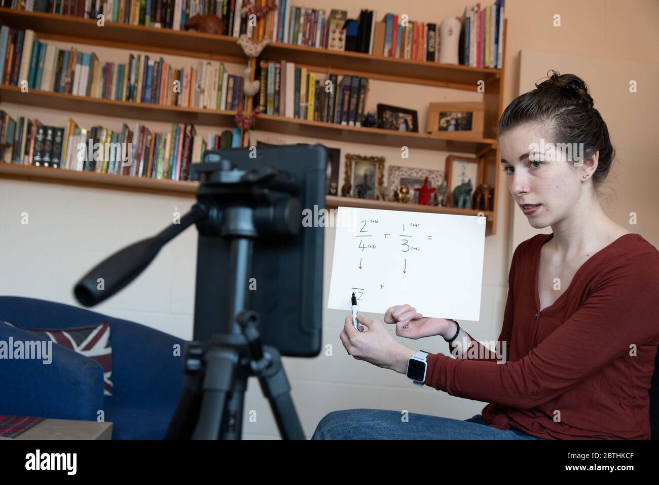 Gli insegnanti della scuola sono costretti ad insegnare le loro lezioni da casa online virtualmente utilizzando i loro telefoni per video se stessi sotto covid-19 coronavirus UK USA Foto Stock