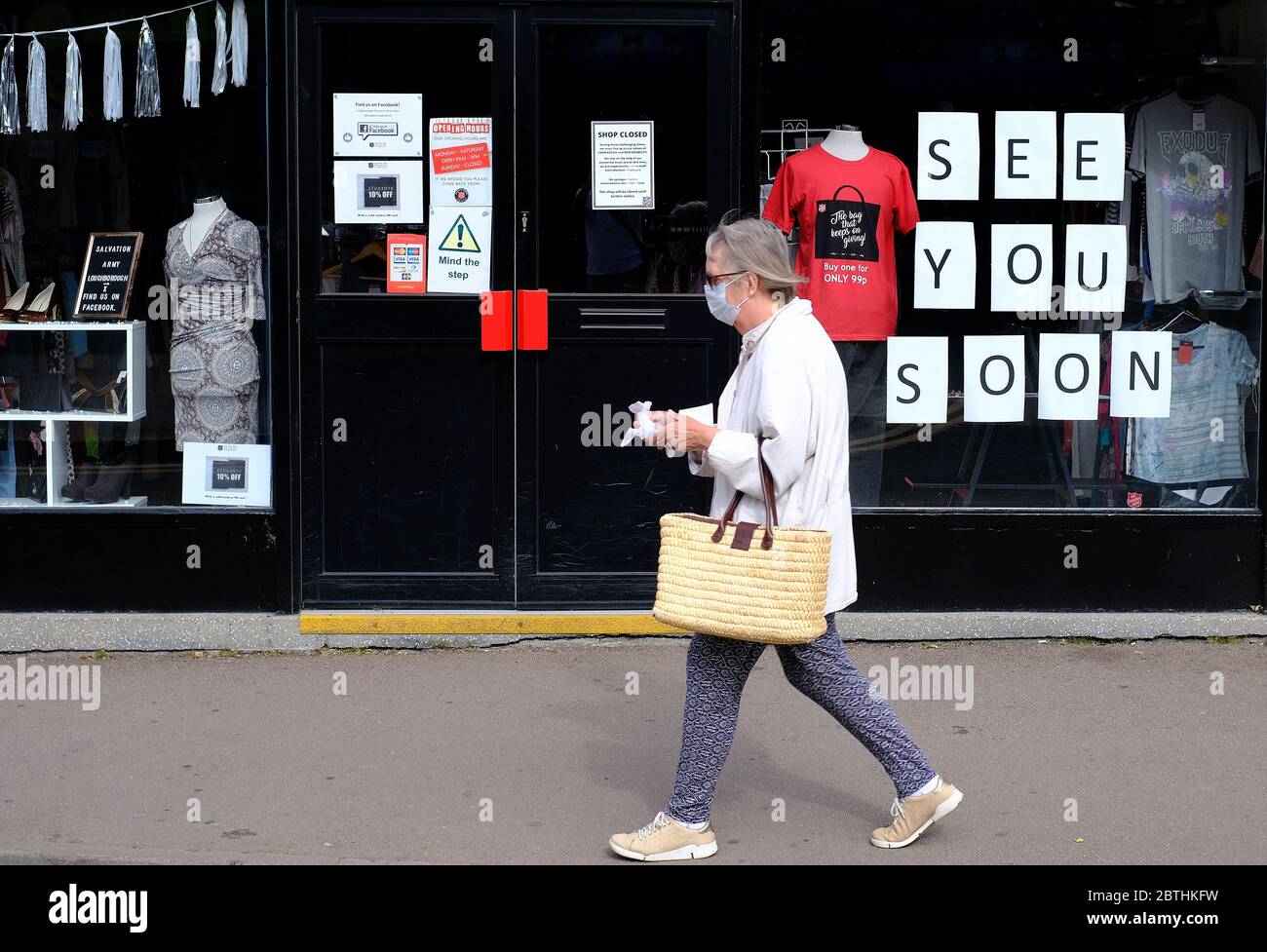 Loughborough, Leicestershire, Regno Unito. 26 maggio 2020. Una donna mascherata passa davanti a un negozio di beneficenza chiuso dell'Esercito della salvezza dopo che Boris Johnson ha annunciato che i rivenditori non essenziali saranno in grado di riaprire in Inghilterra dal 15 giugno, durante il blocco pandemico del coronavirus. Credit Darren Staples/Alamy Live News. Foto Stock