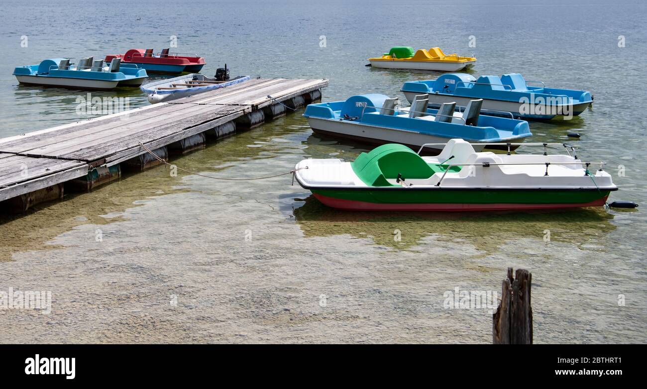 Utting, Germania. 26 Maggio 2020. Le colorate pedalò sono ormeggiate presso un molo sull'Ammersee. Credit: Sven Hoppe/dpa/Alamy Live News Foto Stock