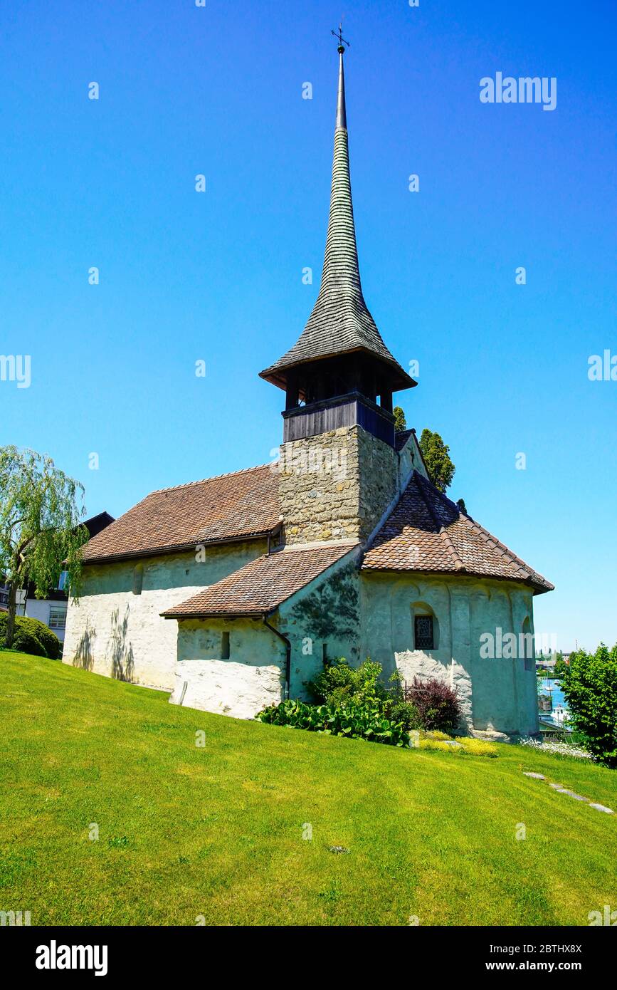 La chiesa del villaggio di Einingen è idilliamente situata sulle rive del lago Thun (Thunersee). Oberland Bernese, Berna, Svizzera. Foto Stock