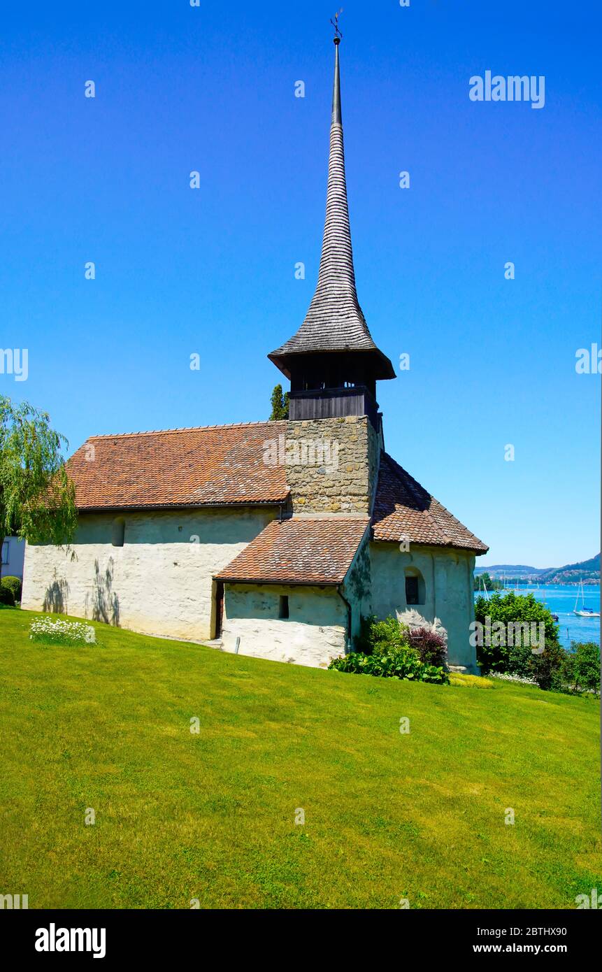 La chiesa del villaggio di Einingen è idilliamente situata sulle rive del lago Thun (Thunersee). Oberland Bernese, Berna, Svizzera. Foto Stock