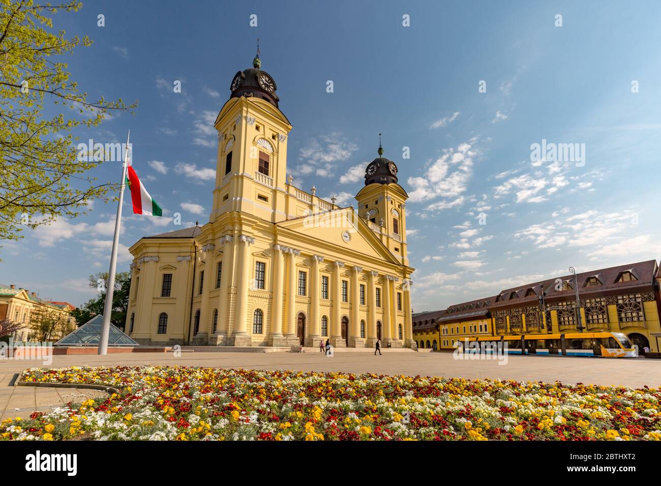 Riformata Grande Chiesa nella città di Debrecen, Ungheria. Centro storico con statue e giardino fiorito Foto Stock