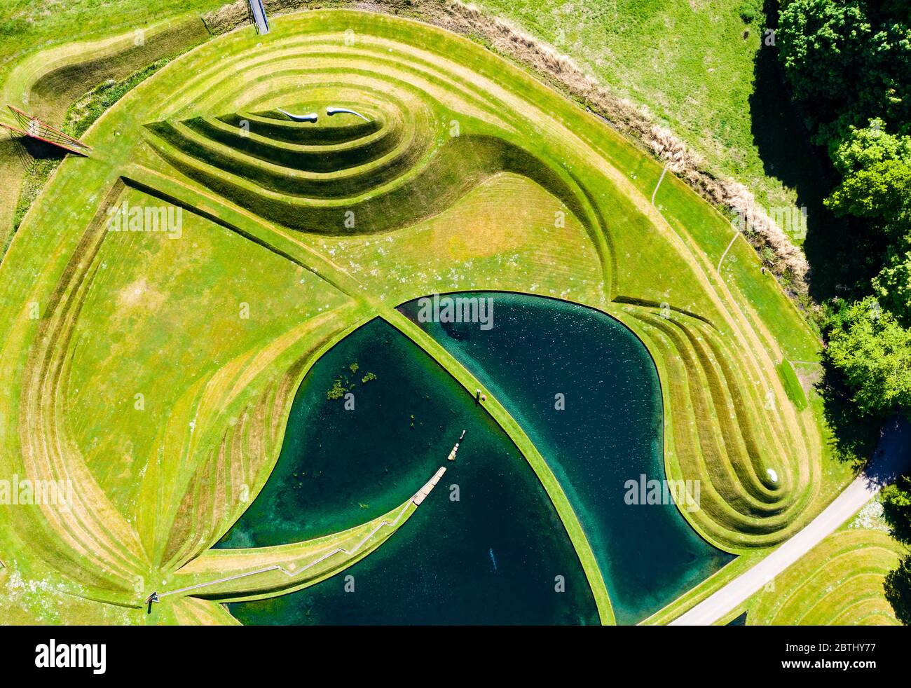 Wilkieston, Scozia, Regno Unito. 26 maggio 2020. Thomas Unterdorfer, custode del paesaggio a Giove Artland, tagliando l'erba sulle sculture in terraferma celle di vita di Charles Jencks. Jupiter Artland spera di avere un'apertura limitata nel prossimo futuro, quando le regole di blocco di Covid-19 sono rilassati. Iain Masterton/Alamy Live News Foto Stock