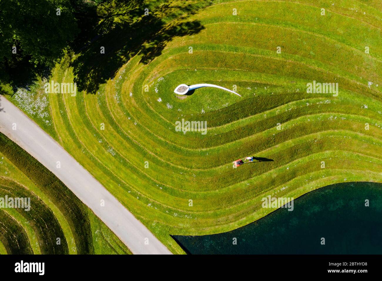 Wilkieston, Scozia, Regno Unito. 26 maggio 2020. Thomas Unterdorfer, custode del paesaggio a Giove Artland, tagliando l'erba sulle sculture in terraferma celle di vita di Charles Jencks. Jupiter Artland spera di avere un'apertura limitata nel prossimo futuro, quando le regole di blocco di Covid-19 sono rilassati. Iain Masterton/Alamy Live News Foto Stock