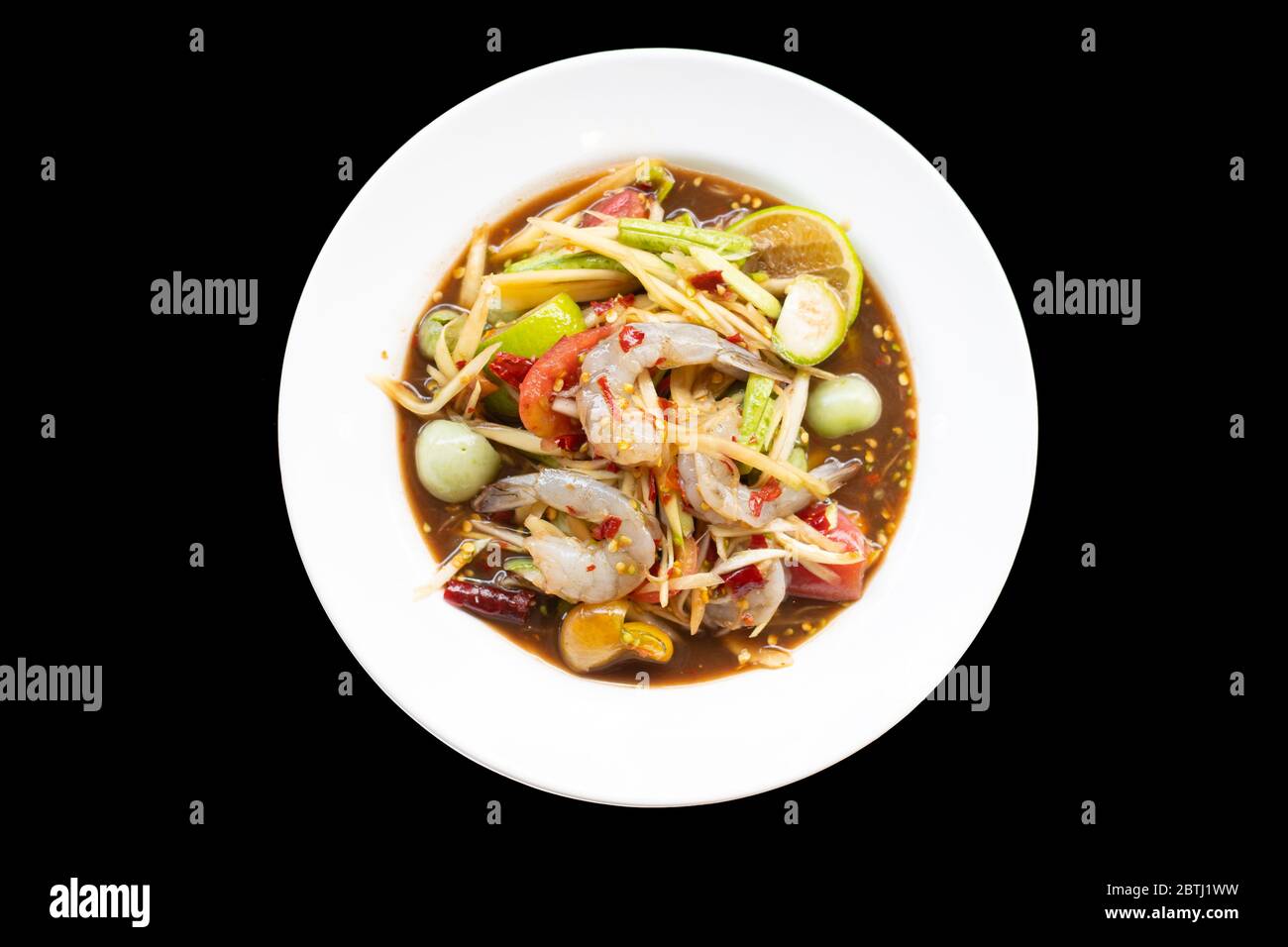 Insalata di papaya con gamberi in ciotola bianca isolata su fondo nero. Cibo tailandese delizioso e popolare Foto Stock